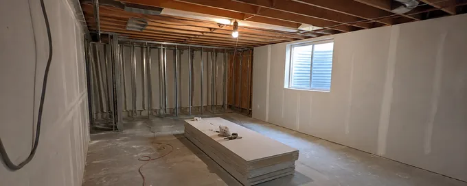 Unfinished Arvada, CO basement partway through being drywalled, framing and ductwork exposed