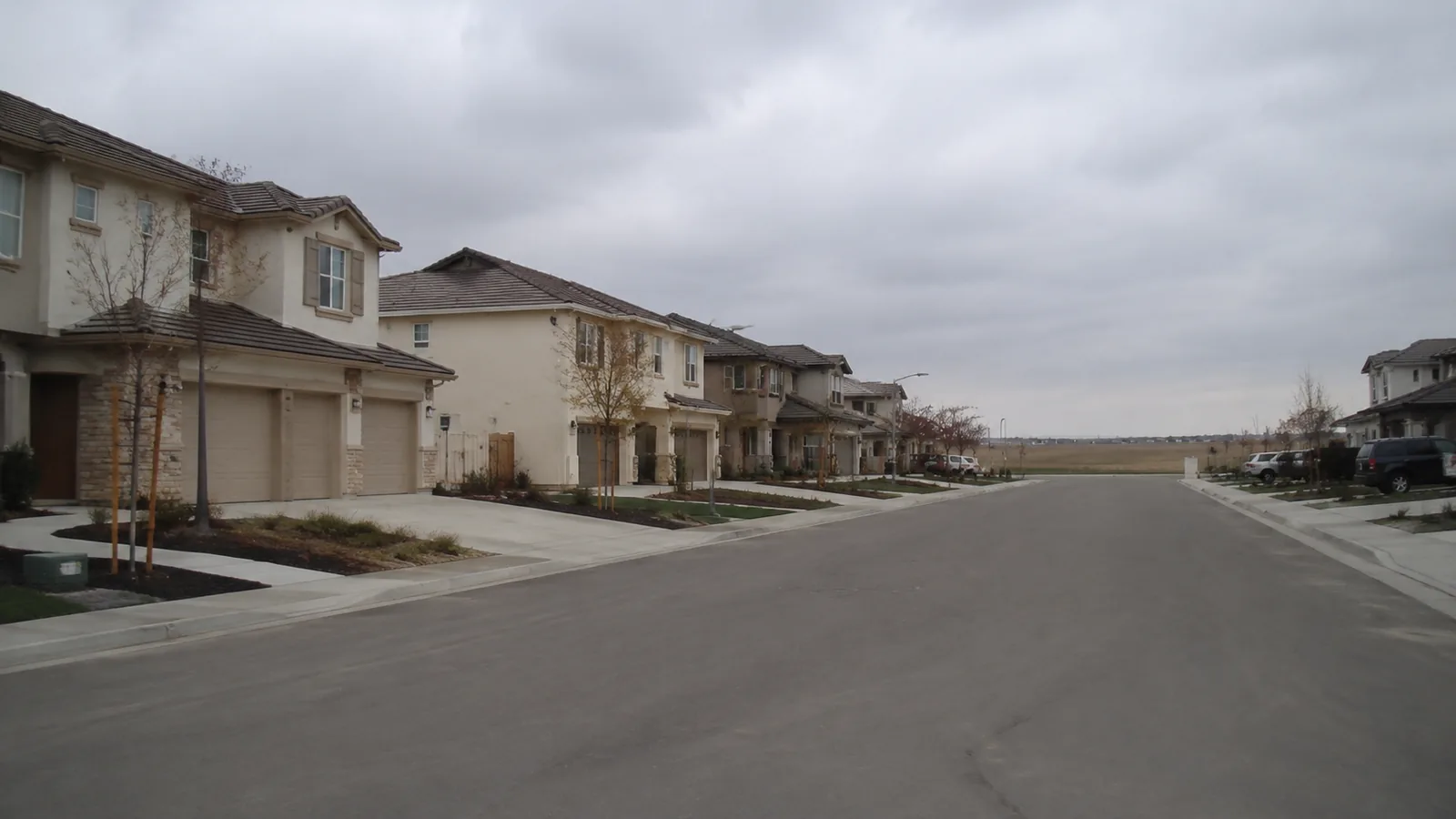 Early 2000s stucco and stone houses on a wide street in Broomfield, CO