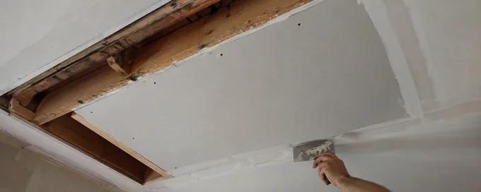 Cut-out section of a residential ceiling in Arvada, CO with a new gypsum board patch fitted between the joists