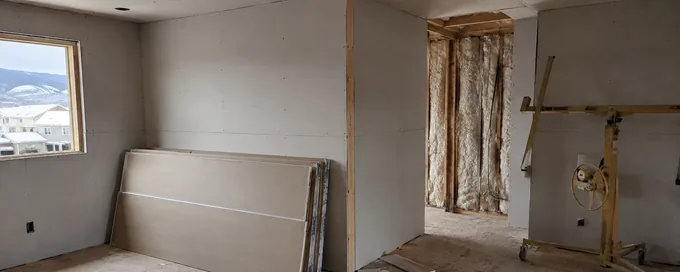 New gypsum board hung on wood stud framing in a partly finished Arvada, CO interior