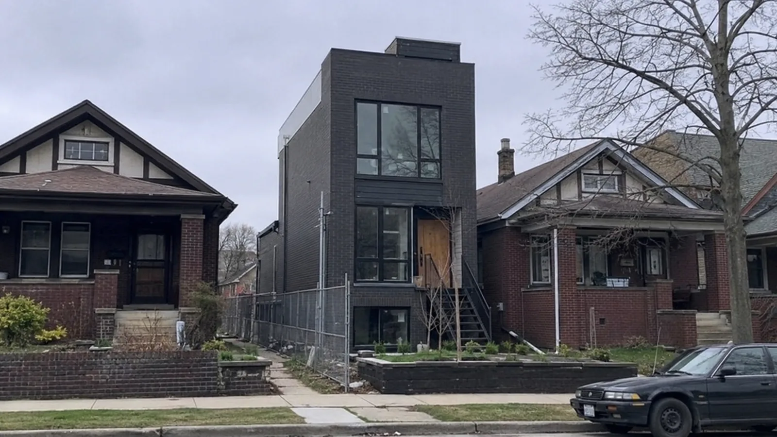 Brick bungalows with a modern infill house between them in northwest Denver, CO