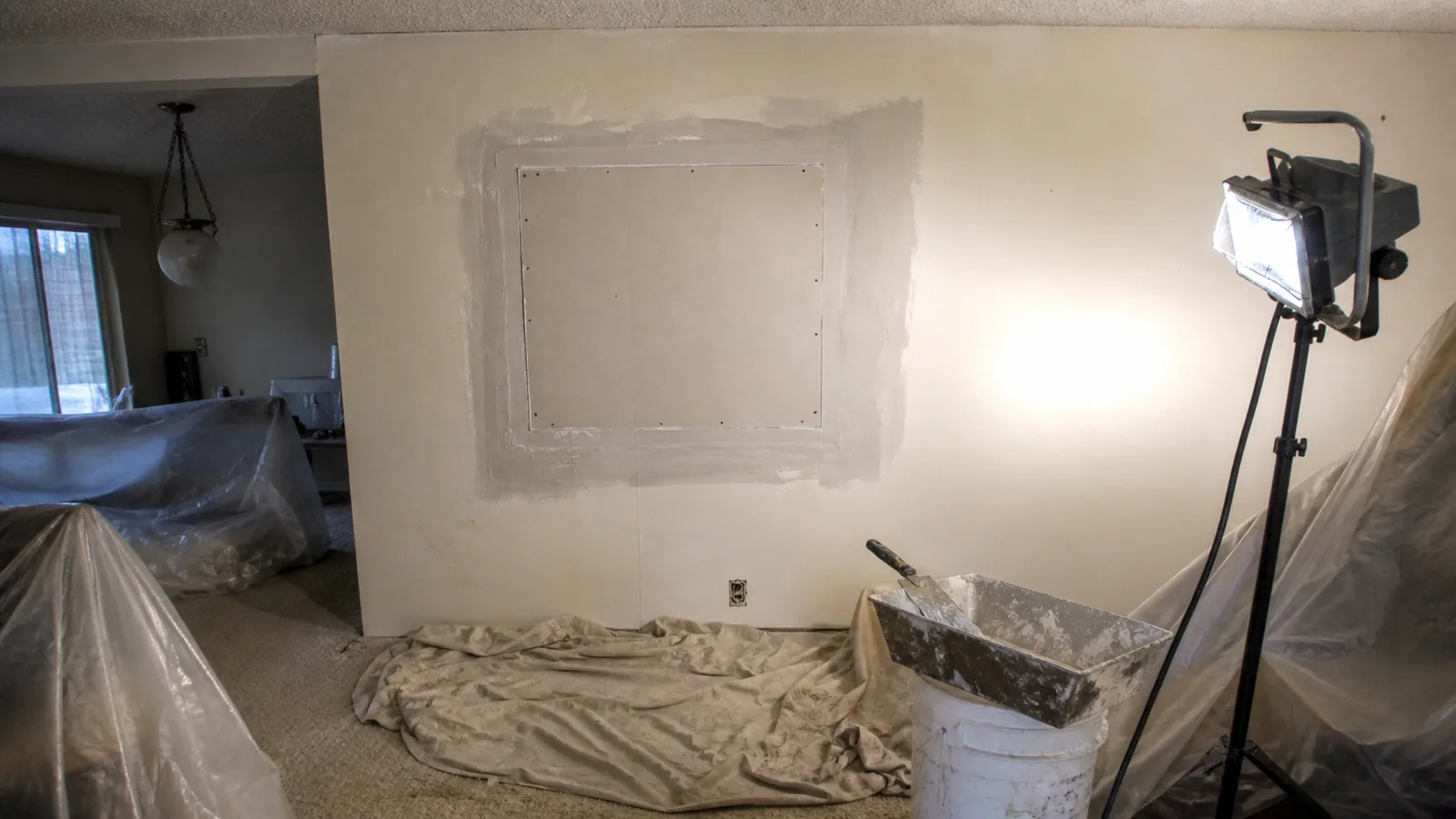 Taped drywall patch with wet joint compound feathered around it in an Arvada, CO living room